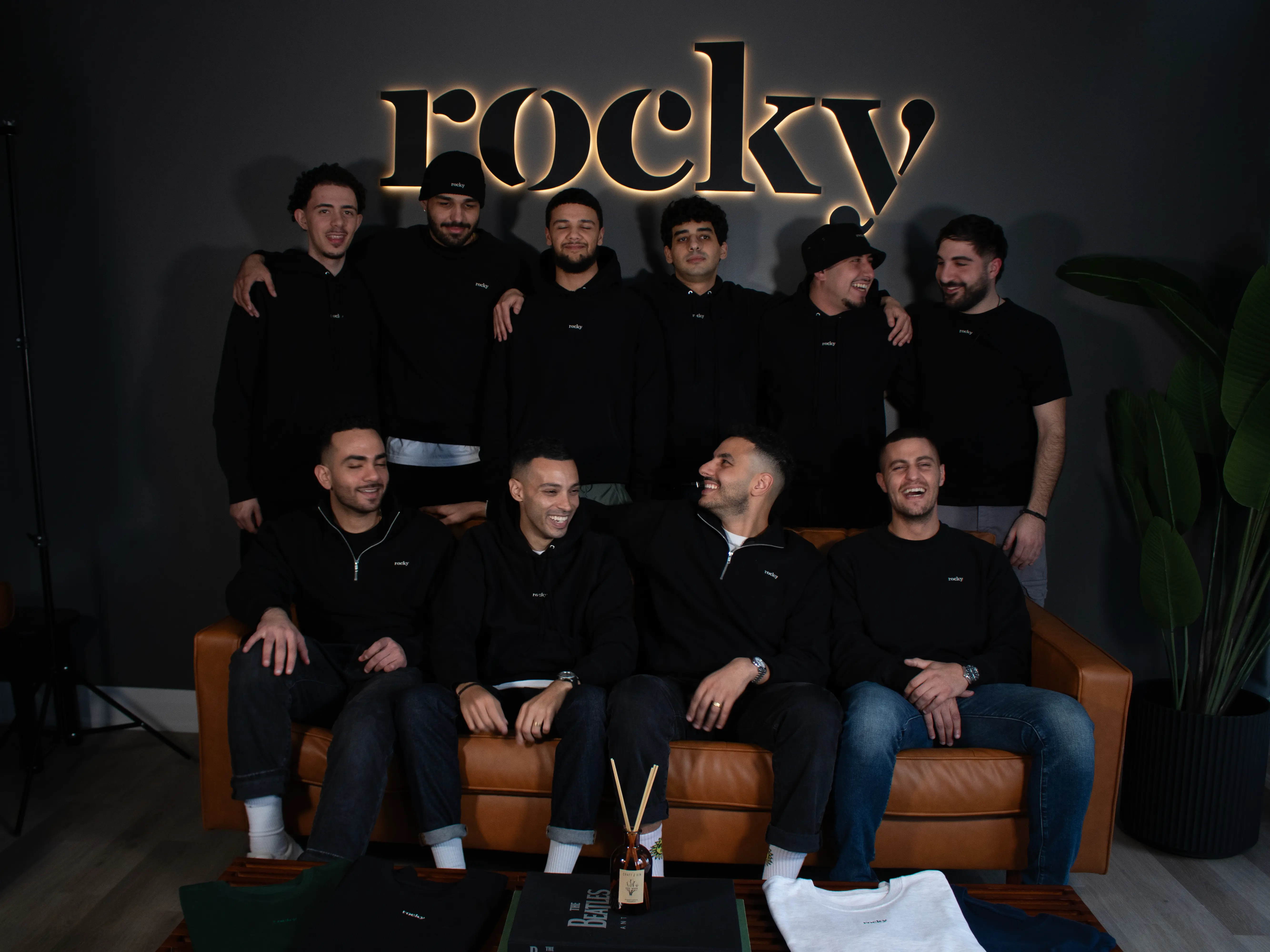 Group of men in black hoodies with illuminated MyRocky sign